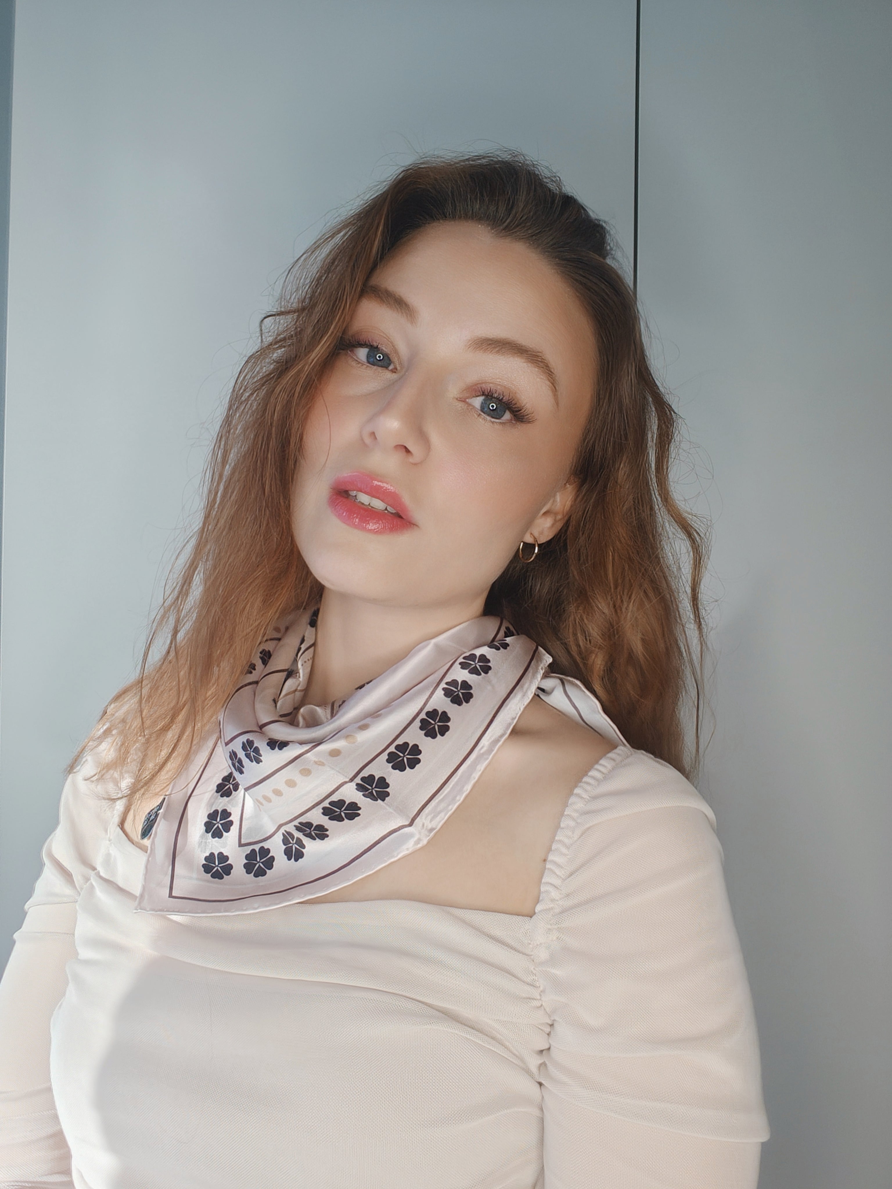 Kvinde iført LA SUIT Firkløver Silketørklæde bundet i nakken.