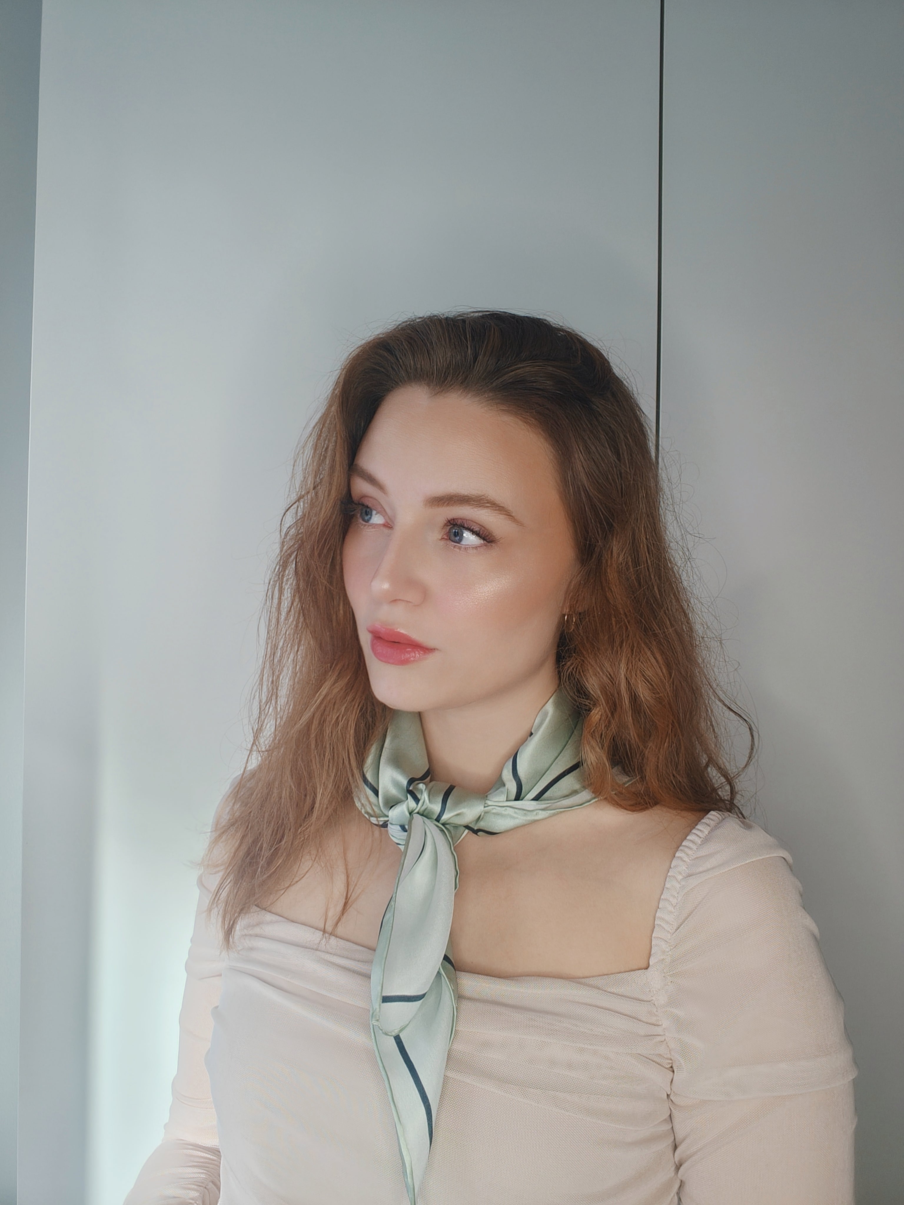 Kvinde iført LA SUIT Pistachio Silketørklæde bundet rundt om halsen.