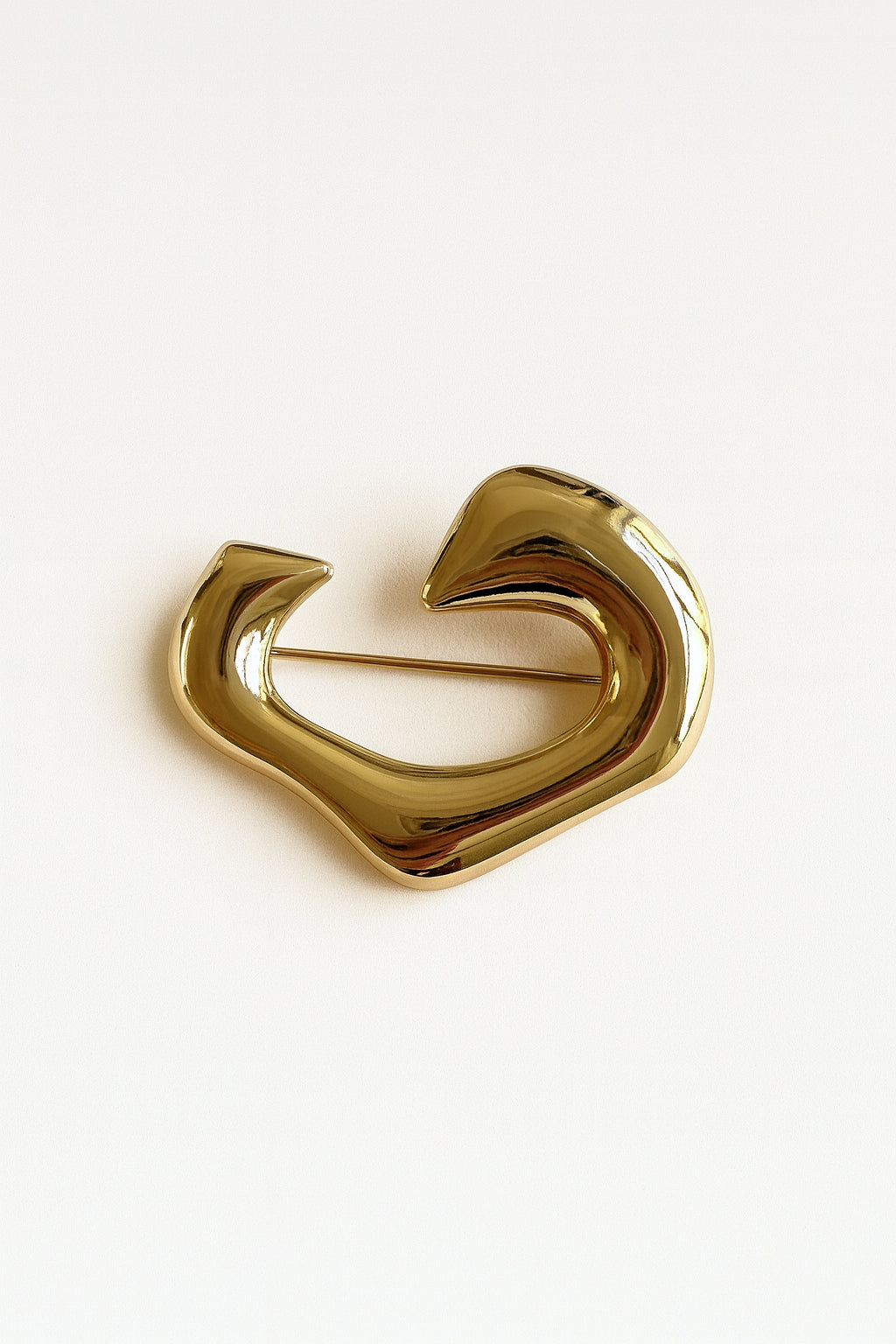 Golden Wave Broche – et skulpturelt design, der kombinerer kunst og elegance i ét eksklusivt accessory.