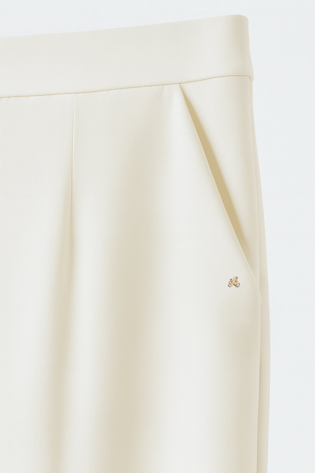 Ivory bryllupsbukser til kvinder med høj talje, pressefolder og gylden monogramdetalje – ideel til brudeoutfit og rådhusbryllup.