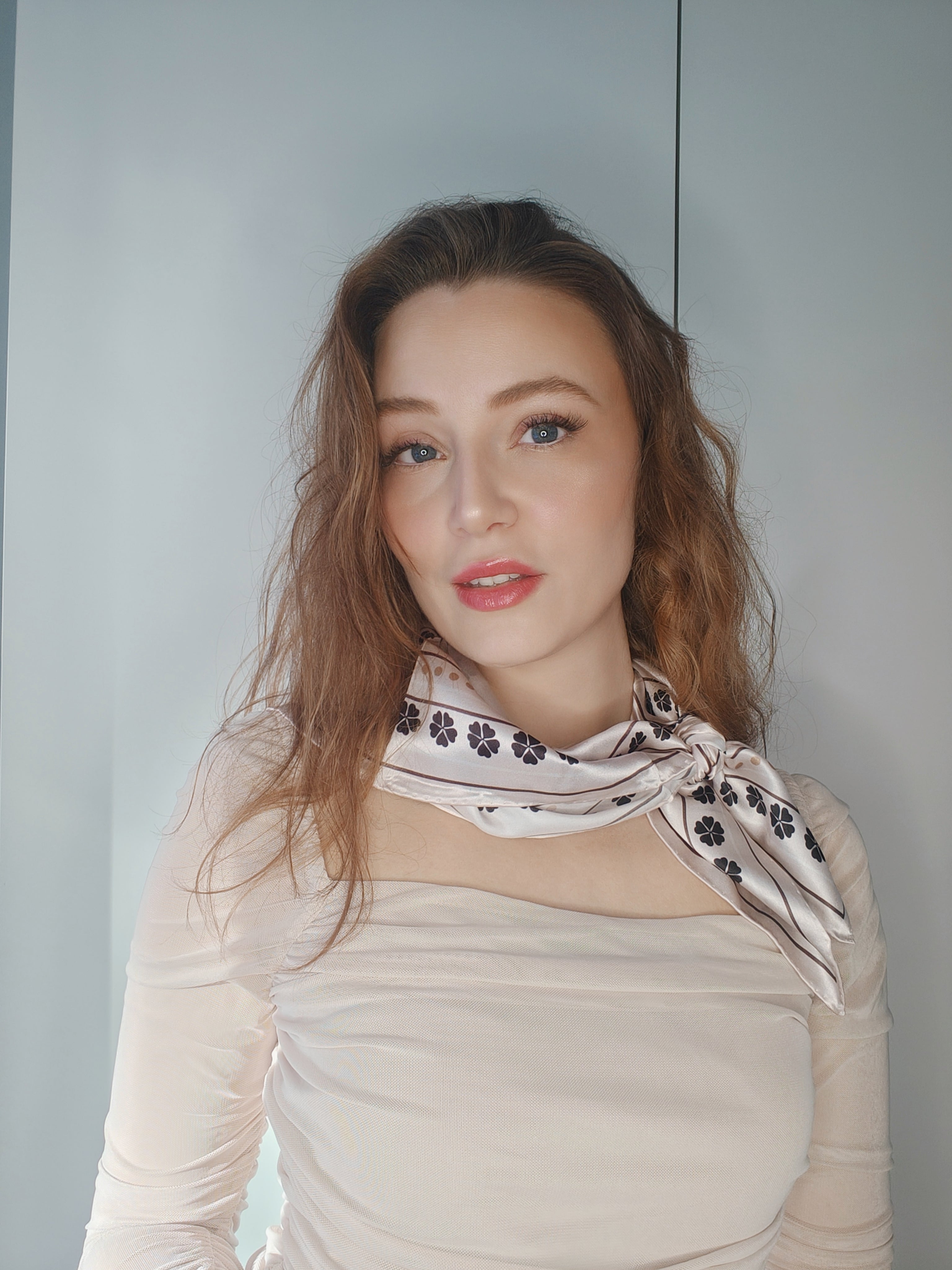 Kvinde iført LA SUIT Firkløver Silketørklæde bundet rundt om halsen.