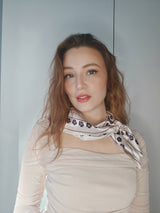 Kvinde iført LA SUIT Firkløver Silketørklæde bundet rundt om halsen.