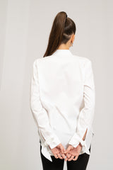 Hvid skjorte med moderne detaljer, heriblandt sløjfer på manchet.