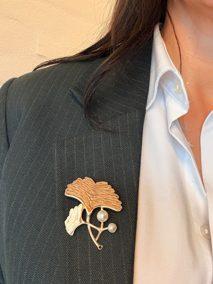 Gyldne nuancer med et kunstnerisk, blomsterinspireret design og perle detaljer. 