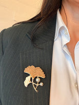 Gyldne nuancer med et kunstnerisk, blomsterinspireret design og perle detaljer. 