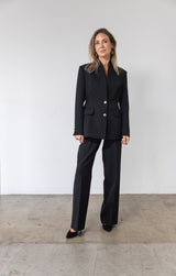 Elegant sort blazer med guld knapper.
