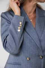 Klassisk blå kvindeblazer med detaljer.