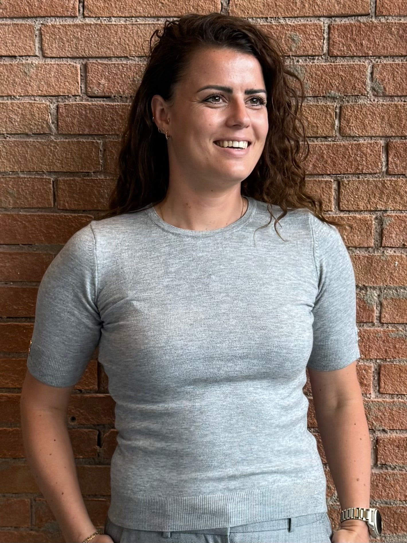 grå bluse med guld knapper og kort ærmet