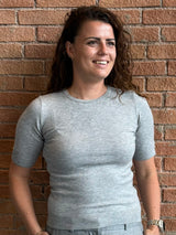 grå bluse med guld knapper og kort ærmet