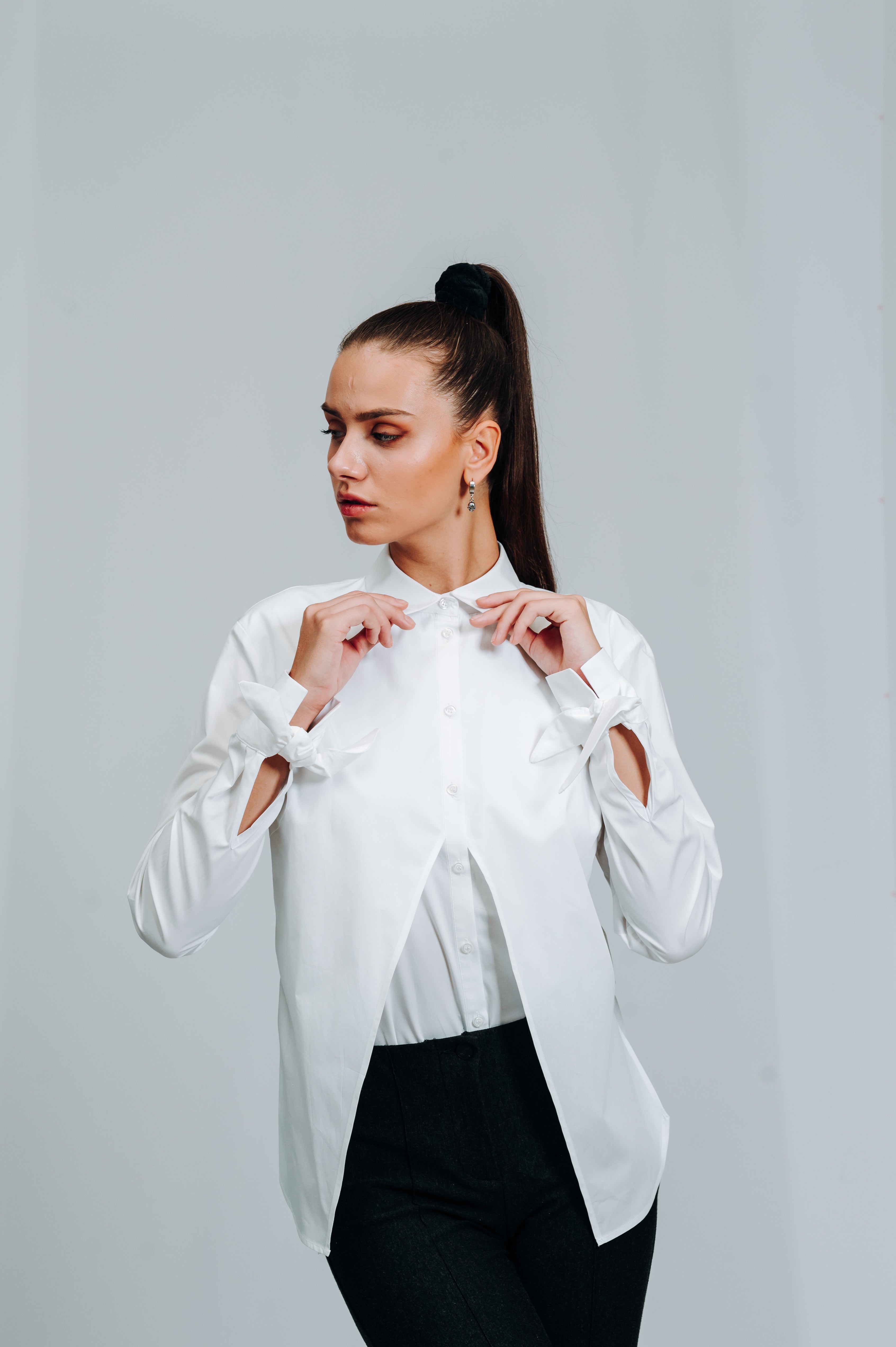 Hvid skjorte med moderne detaljer, heriblandt sløjfer på manchet og ydre kappedetalje. slimfit skjorte