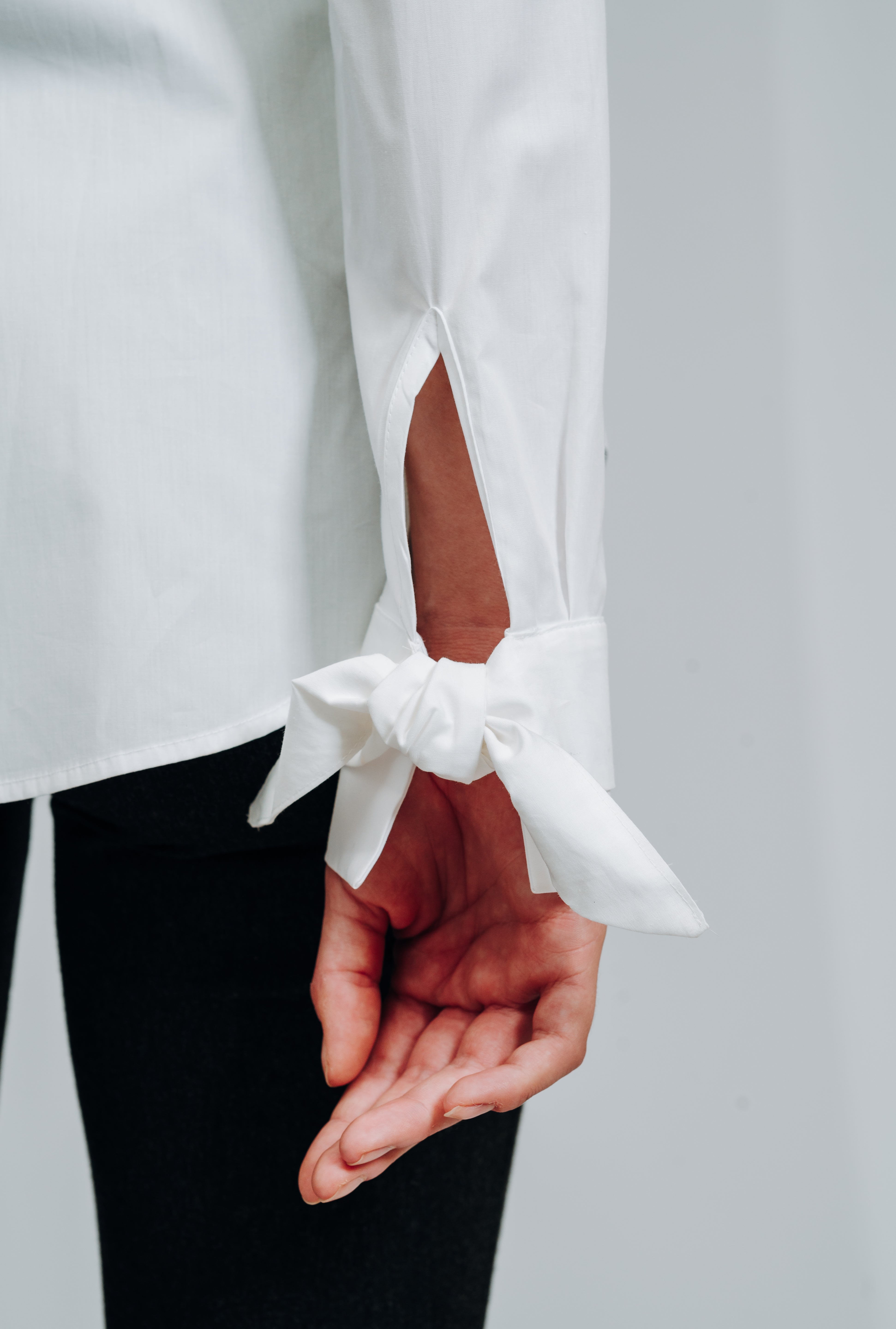Hvid skjorte med moderne detaljer, heriblandt sløjfer på manchet. skjorte med fin detaljer