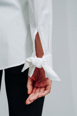 Hvid skjorte med moderne detaljer, heriblandt sløjfer på manchet. skjorte med fin detaljer